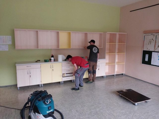 Montaža pohištva za šolsko učilnico – omare in regali z rumenimi poudarki