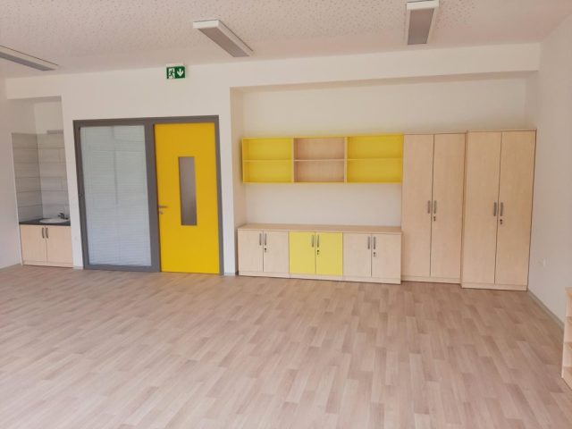 Omare in regali z rumenimi poudarki v šolski učilnici